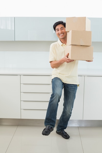 Souriant décontracté jeune homme transportant des boîtes