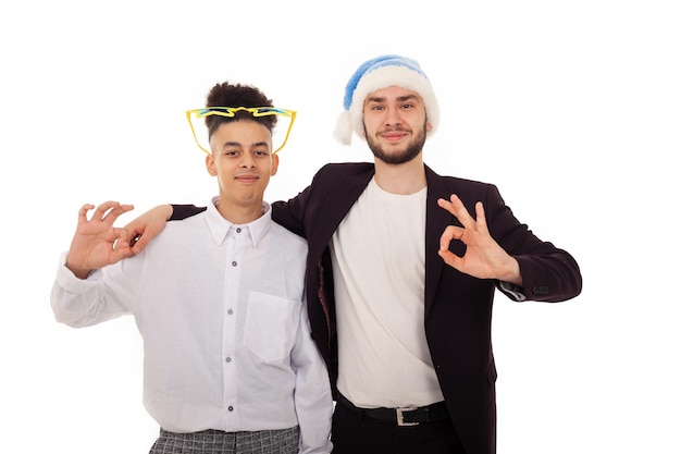 Souriant deux amis internationaux portant un bonnet de Noel et des lunettes de grande étoile se serrant les coudes