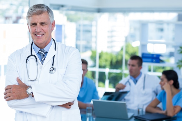 Souriant, docteur, regarder appareil-photo, à, bras croisés