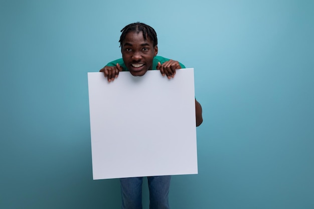 Souriant drôle jeune homme africain tenant un panneau d'affichage avec maquette