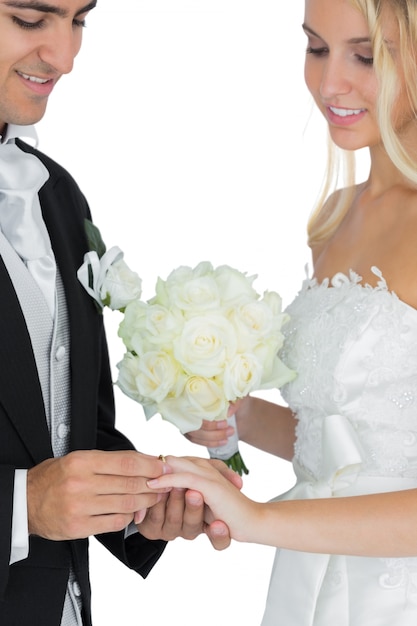 Souriant époux mettant la bague de mariage sur son doigt wifes