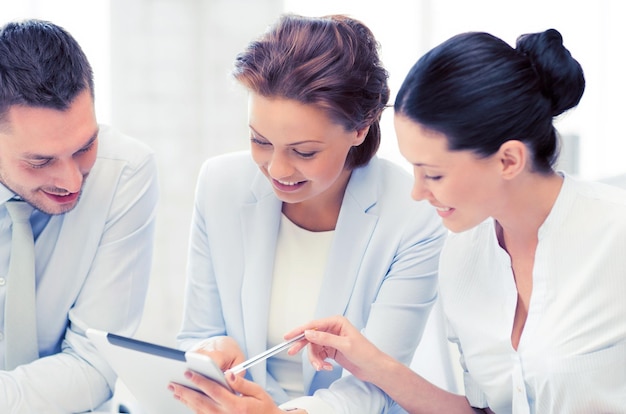 Souriant équipe travaillant avec des tablet PC au bureau