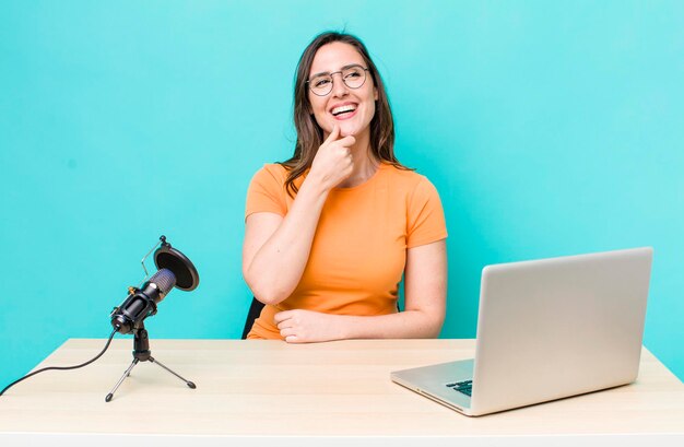 Souriant avec une expression heureuse et confiante avec la main sur le menton