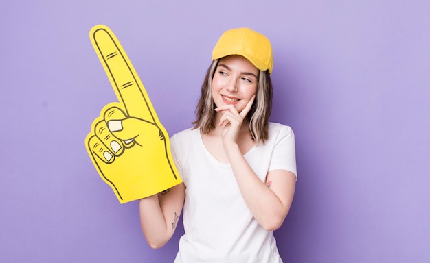 Souriant avec une expression heureuse et confiante avec la main sur le menton