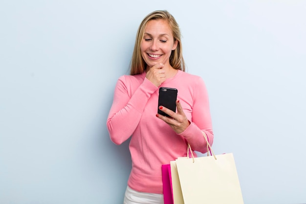 Souriant avec une expression heureuse et confiante avec la main sur le menton