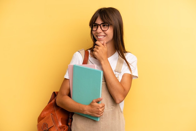 Souriant avec une expression heureuse et confiante avec la main sur le menton