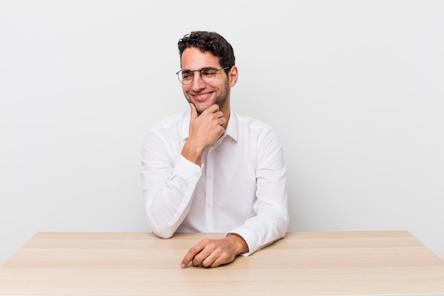 Souriant avec une expression heureuse et confiante avec la main sur le menton