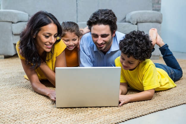 Souriant famille utilisant un ordinateur portable dans le salon