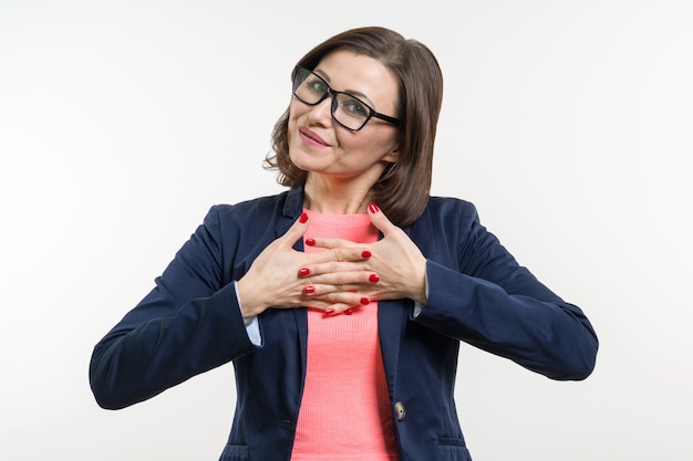 Souriant femme d'âge moyen avec les bras croisés sur blanc