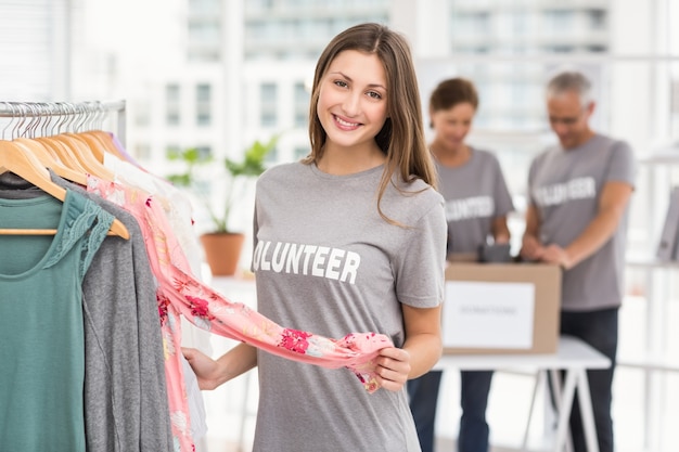 Souriant, femme volontaire, choisir des vêtements