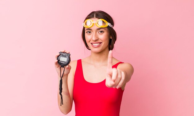 souriant fièrement et avec confiance faisant le numéro un