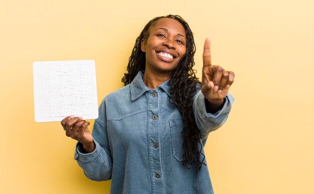 souriant fièrement et avec confiance faisant le numéro un