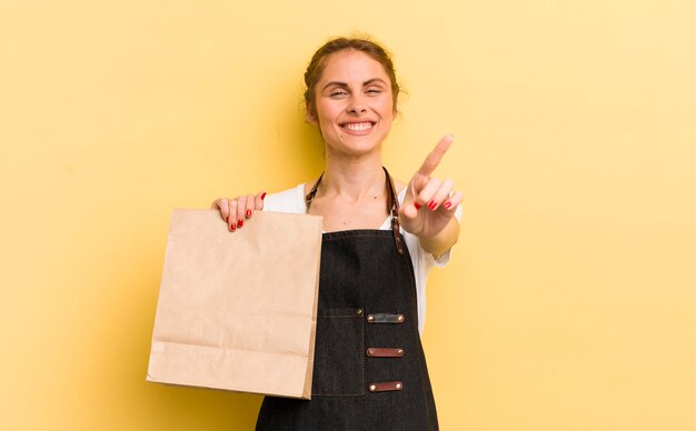 souriant fièrement et avec confiance faisant le numéro un