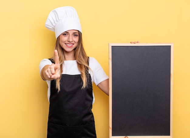 souriant fièrement et avec confiance faisant le numéro un