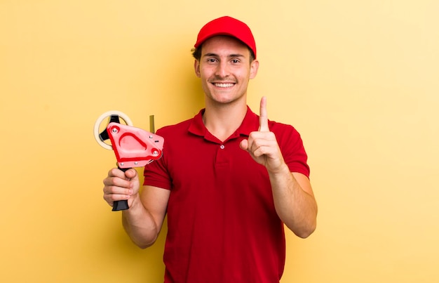 souriant fièrement et avec confiance faisant le numéro un