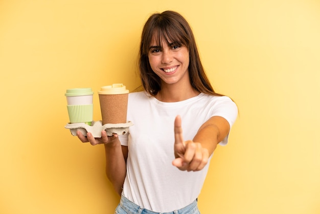 souriant fièrement et avec confiance faisant le numéro un