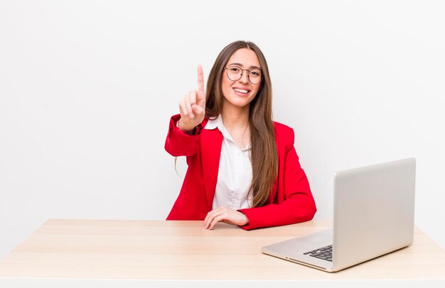 souriant fièrement et avec confiance faisant le numéro un