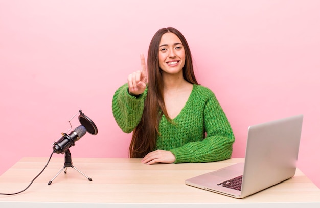 souriant fièrement et avec confiance faisant le numéro un