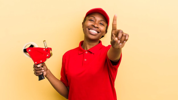 souriant fièrement et avec confiance faisant le numéro un