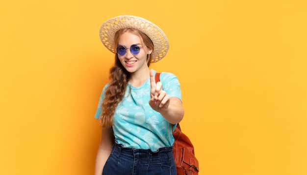 souriant fièrement et avec confiance en faisant la pose du numéro un triomphalement, se sentant comme un leader