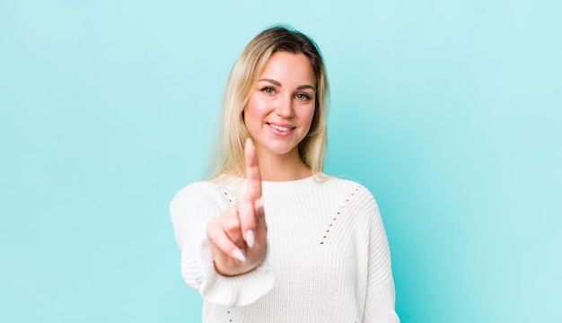 souriant fièrement et avec confiance en faisant la pose numéro un se sentant triomphalement comme un leader