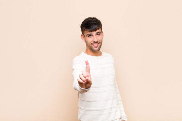 souriant fièrement et en toute confiance faisant triompher la pose numéro un, se sentant comme un leader