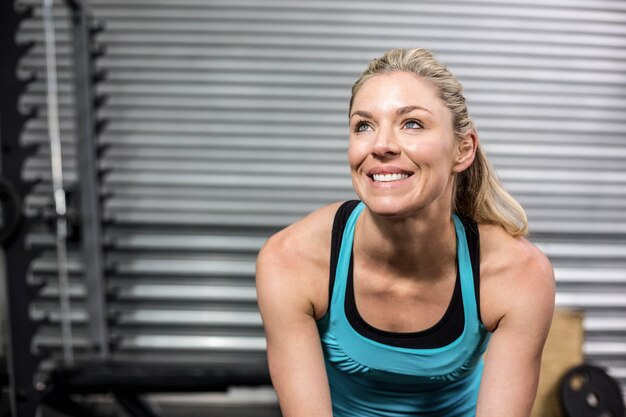 Souriant fit femme assise au gymnase