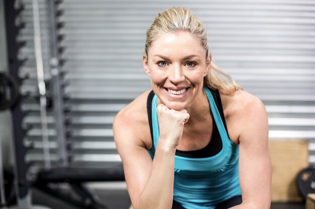 Souriant fit femme assise au gymnase