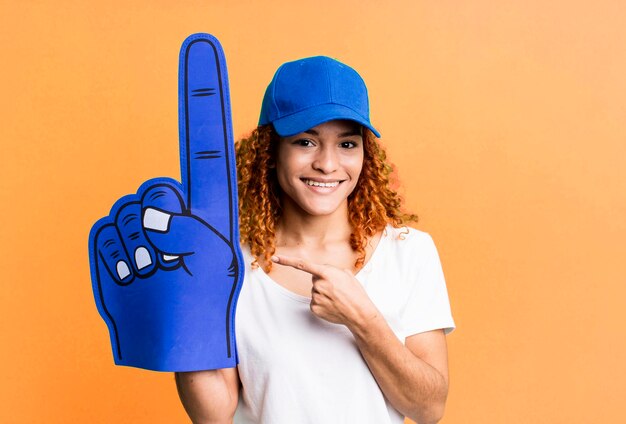 Souriant gaiement se sentant heureux et pointant vers le côté