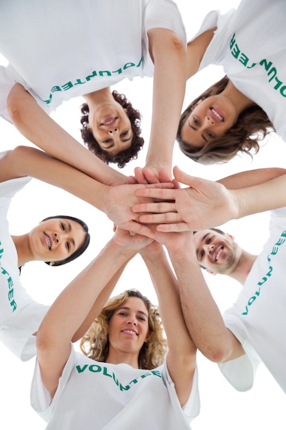 Souriant groupe de bénévoles empiler leurs mains