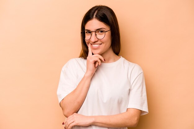 Souriant heureux et confiant touchant le menton avec la main