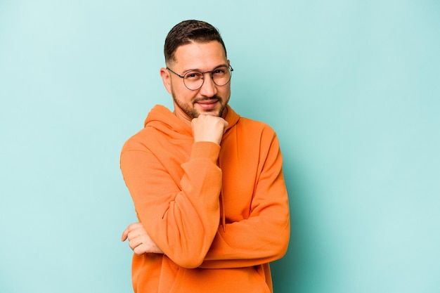 Souriant heureux et confiant touchant le menton avec la main