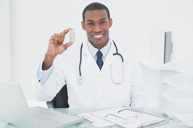 Souriant homme médecin tenant une bouteille de prescription