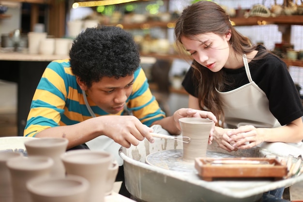 Souriant jeune couple dans un atelier de poterie
