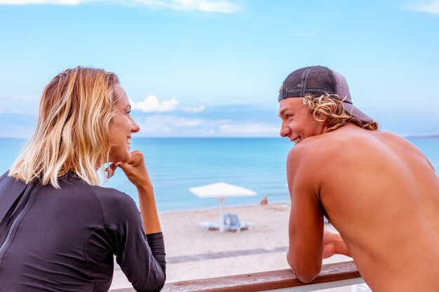 Souriant Jeune Couple De Surfeurs Actifs Se Détendre Sur La Plage Après Le Sport