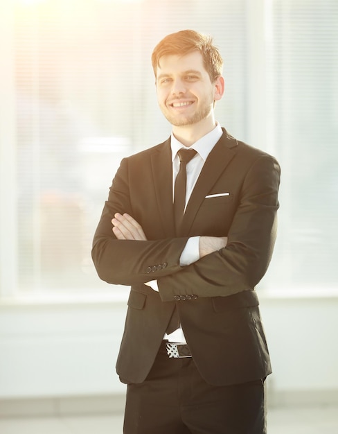 Souriant jeune homme d'affaires sur le bureau d'arrière-plan flou