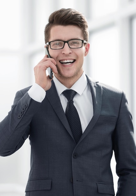 Souriant jeune homme d'affaires parlant sur le concept d'entreprise de smartphone