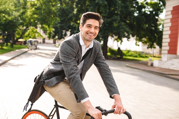 Souriant jeune homme d'affaires à vélo