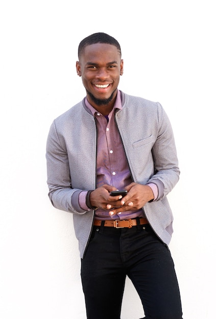 Souriant jeune homme africain debout avec un téléphone mobile