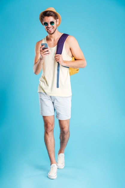 Souriant jeune homme à l'aide de smartphone