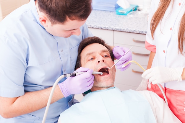 Souriant jeune homme en attente d'un examen dentaire chez un dentiste