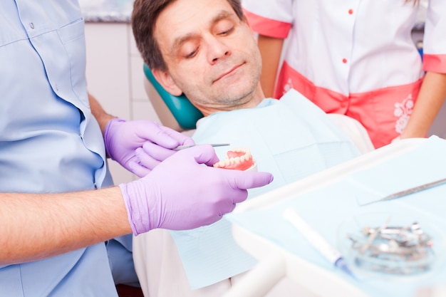 Souriant jeune homme en attente d'un examen dentaire chez un dentiste