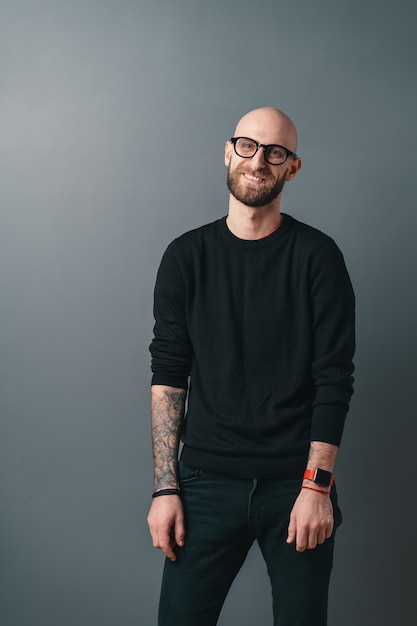 Souriant jeune homme barbu sur fond gris