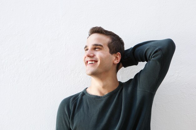 Souriant jeune homme avec la main dans les cheveux