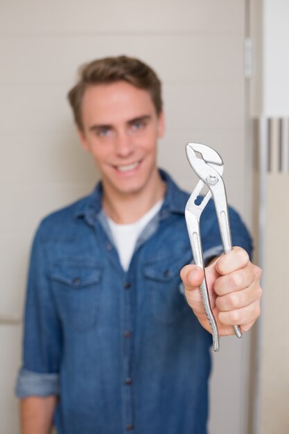 Souriant jeune homme à tout faire tenir une clé