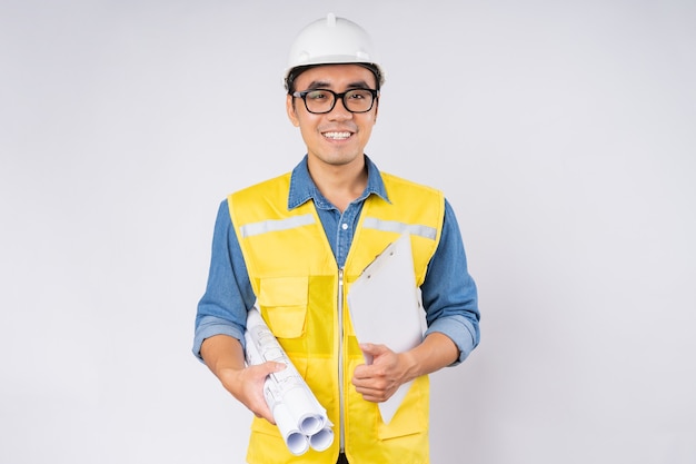 Souriant jeune ingénieur civil asiatique portant un casque casque debout sur fond blanc isolé. Concept de service mécanique.