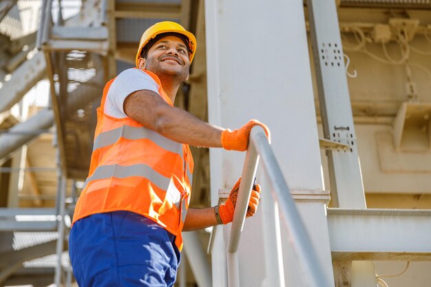 Souriant jeune ingénieur en construction travaillant dans une usine