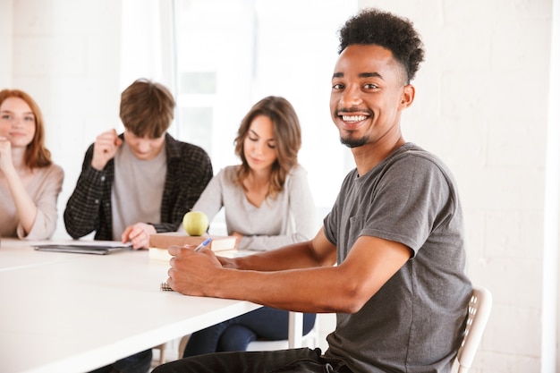 Souriant jeune mec africain en classe