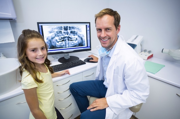 Souriant jeune patient et dentiste en clinique dentaire