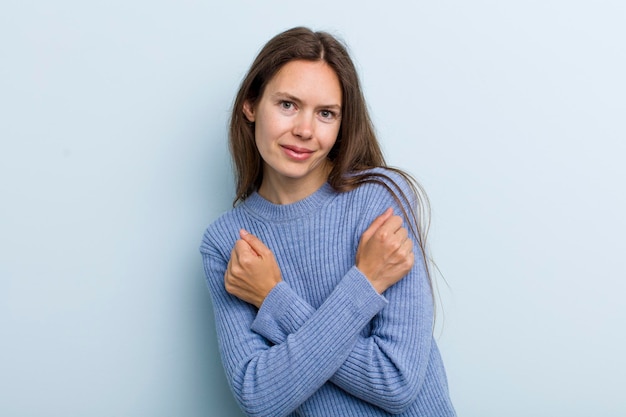 souriant joyeusement et célébrant avec les poings serrés et les bras croisés se sentant heureux et positif